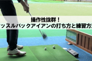 ゴルフ練習場でアイアンを使ってボールを打ち込むゴルファー